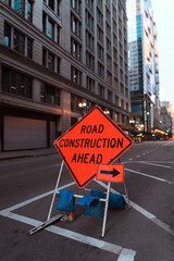 Road Construction Ahead Sign in Urban City Street at Dusk