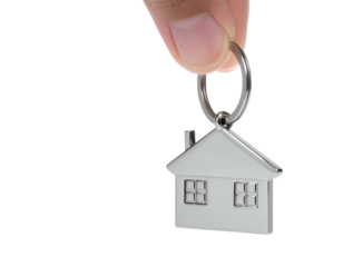 Metal house-shaped pendant on keyring held by fingers