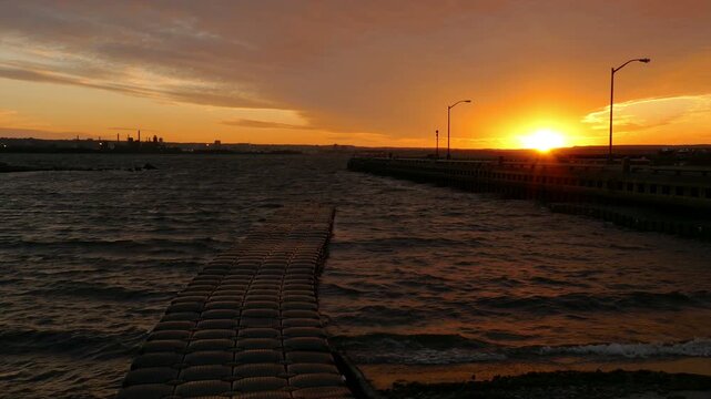 Sunset waves and waving dock on Hamilton Harbour in Hamilton, Ontario, Canada.