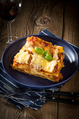 Piece of tasty hot lasagna with red wine.
