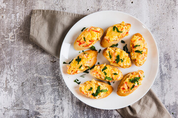Close up of mini baked sandwiches with crab sticks, egg and cheese on a plate on the table top view