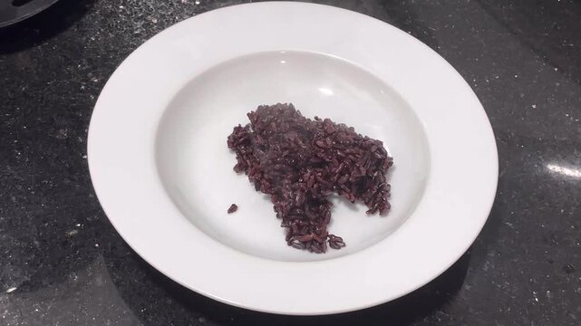 Scooping out freshly cooked riceberry rice.