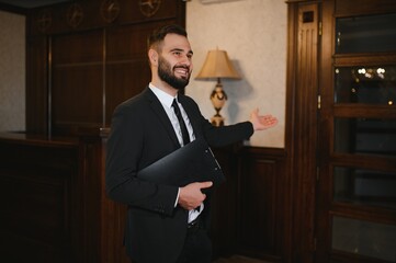 Hotel receptionist welcoming guest, offering hospitality service