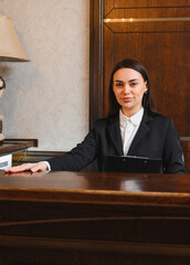 Hotel receptionist welcoming guest at front desk