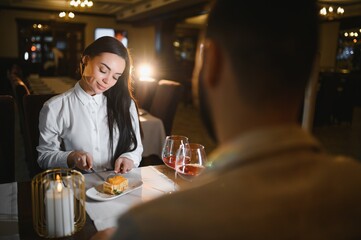 Couple enjoying romantic dinner date with dessert and wine