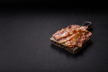 Fried smoked bacon slices, ham, jamon, or prosciutto strips for cooking. Fried bacon