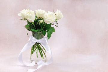 Elegant bouquet of white roses in glass vase isolated on soft pastel background