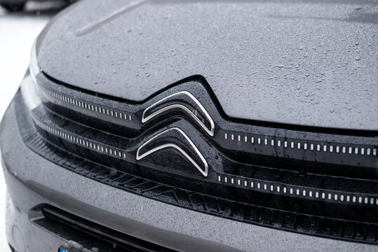 Kyiv, Ukraine, December 14, 2025. Close-up of a new Citro&euml;n car emblem on a modern vehicle front, covered with raindrops, showcasing automotive design and branding.