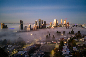 Obraz premium Sunrise Over Foggy Burnaby Skyline With Tall Buildings And Residential Neighborhoods
