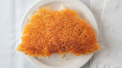 Golden Persian tahdig with a crunchy rice crust on a white plate.