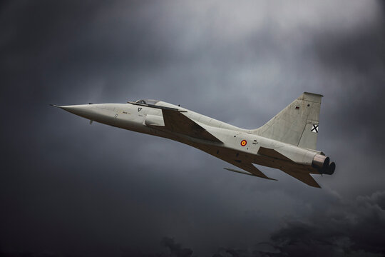 military Northrop F-5 supersonic light fighter jet on a cloudy sky