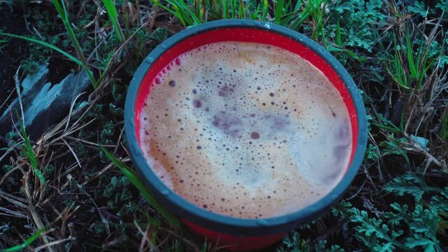 Close up of Fresh Coffee Beng Poured into Red Cup Outoors