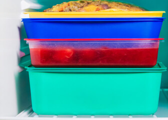 a refrigerator with three containers of food in it