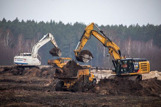 Articulated dump trucks and excavator on a construction site. Construction equipment. Heavy machines. Construction site.