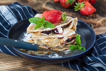 Polish pancakes with jam, cheese and strawberries.