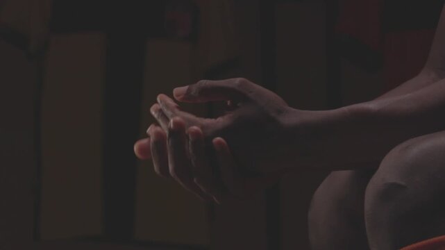 Close-up of  soccer players rubbing their hands together in the locker room. The athletes display nervousness, tension, and anticipation before a big match.
