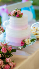 A Two-Tier White and Pink Wedding Cake Decorated with Fresh Roses and Floral Accents
