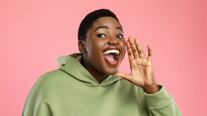 A cheerful woman with short hair is enthusiastically speaking, her mouth wide open as if sharing...