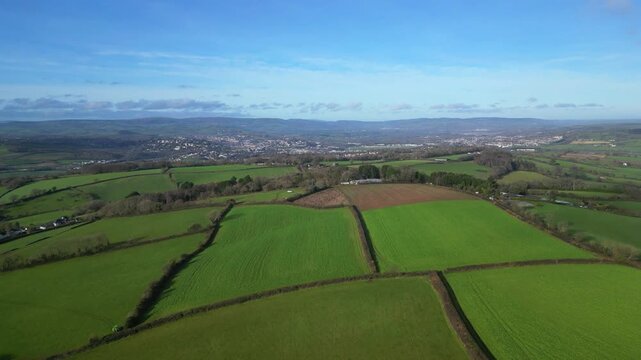 Coffinswell, South Devon, England: DRONE VIEWS: The drone flies over farmland heading towards the market town of Newton Abbot. UK green belt land is increasingly under threat from urban development.