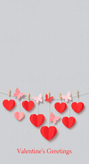 Handmade Valentine's Day hearts and butterflies strung on a line with clothespins