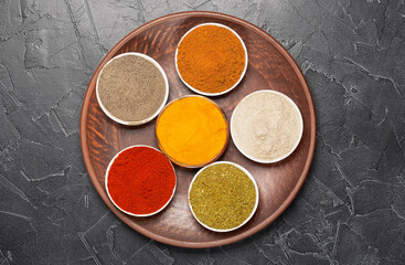 Spices: turmeric, paprika, cardamom, nutmeg, black pepper and allspice on a large platter.