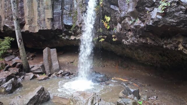 This scenic view captures the unique Hedge Creek Falls waterfall in Dunsmuir, where a short trail allows visitors to walk behind the cascading water