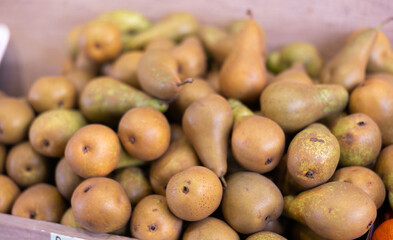 View of ripe pears in a wicker basket, put up for sale in a store