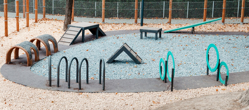 Outdoor park agility training area featuring various obstacles for pet exercise and dog training.