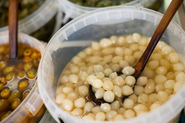 Marinated onion in plastic containers on a shelf in a supermarket