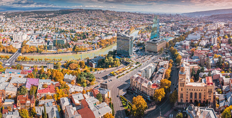 Aerial view of Tbilisi, Georgia, showcasing an autumn cityscape with the Kura River, urban buildings, and historic architecture © EdNurg