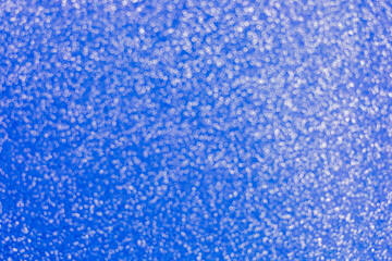 Abstract blurred background in blue with sparkling elements. Represents winter holiday themes like Christmas and New Year.