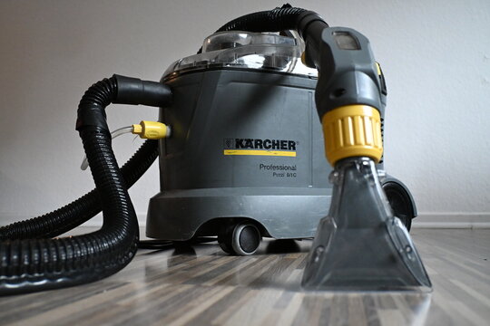 k&auml;rcher Spray extraction device puzzi 8/1, industrial vacuum cleaner  karcher puzzi 8,  with hose and transparent nozzle on wooden floor, 12-14-2025