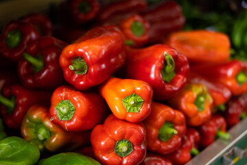 Large red bell peppers on the counter of the vegetable department in the supermarket. Fresh vegetables at the farmers market. Salad ingredients for a healthy lifestyle