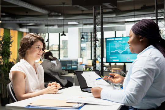 Businesswoman from human resources explains contract deal benefits to a candidate, including salary details, annual wellness programs and rights related to employment and schedule flexibility.