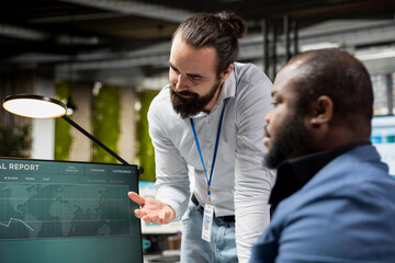 Diverse associates team in a modern office collaborates on project planning, using charts and analytics to drive performance and success while fostering work alliance and synergy.