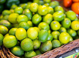 Fresh lime harvest in a box at the grocery store. Citrus fruits for juicing at the market.