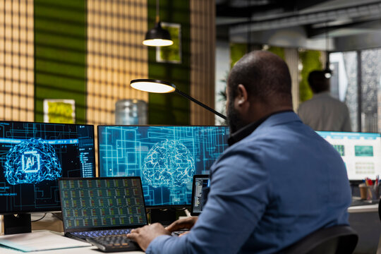 African american person uses AI and deep learning algorithms on analytics platform, optimizing data processing for organizational decision making. IT company digitalization for efficiency. - Powered by Adobe