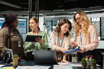 Women associates collaborating over performance metrics for a new financial strategy in a multinational company office. Business partners aligning resources with project objectives.