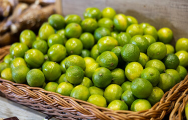 Fresh lime harvest in a box at the grocery store. Citrus fruits for juicing at the market.