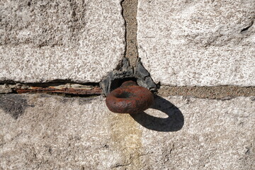 A sharp, high-contrast photograph featuring a weathered stone block wall with an integrated...