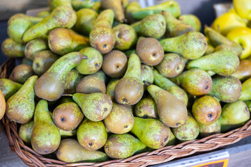 Ripe pear in a container on the counter of a farmers market. Delicious fruits in the supermarket
