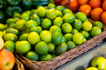 Fresh lime harvest in a box at the grocery store. Citrus fruits for juicing at the market.