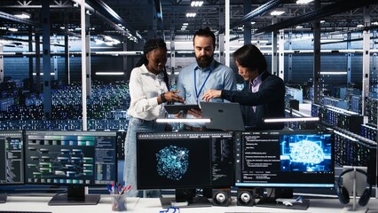 Portrait of smiling engineers in server room using AI to review infrastructure diagnostics. Cheerful IT coworkers in data center analyzing performance data using artificial intelligence, camera A