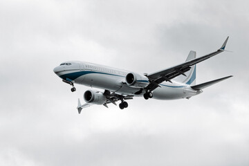 Commercial airplane flying through overcast sky, showcasing sleek design and aerodynamic features, representing modern aviation technology and travel innovation