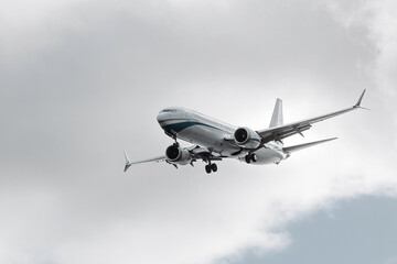 Airplane flying through cloudy sky, showcasing its sleek design and powerful engines, symbolizing modern aviation technology and travel innovation