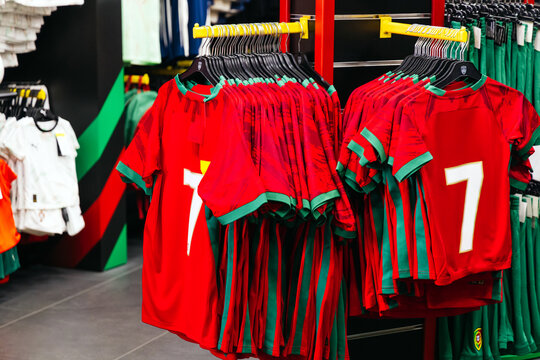 Red and green sports jerseys with number seven displayed on hangers in a retail store, showcasing vibrant colors and athletic apparel for fans and players