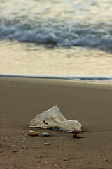 Plastic Waste Scattered on Beach Sand. Plastic waste on beaches is a serious global problem.