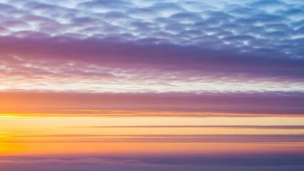 Obraz premium Vibrant sunset with layered clouds and warm hues in the sky