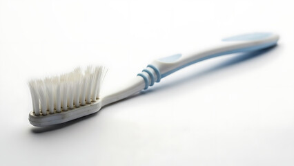 Close-up of a clean white and blue toothbrush with soft bristles on a white background