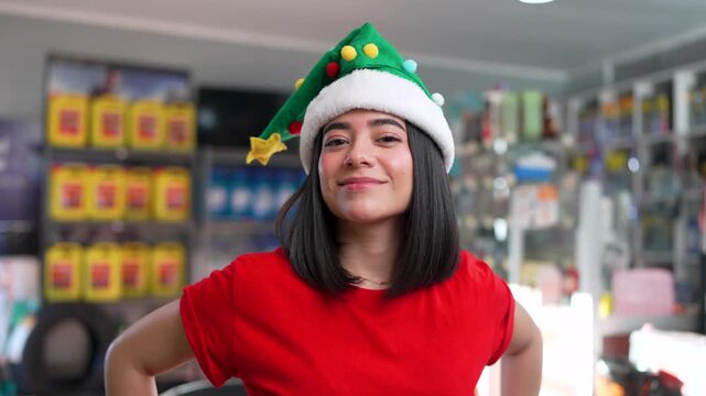 Young hispanic woman wearing a christmas elf hat and smiling in a car parts store